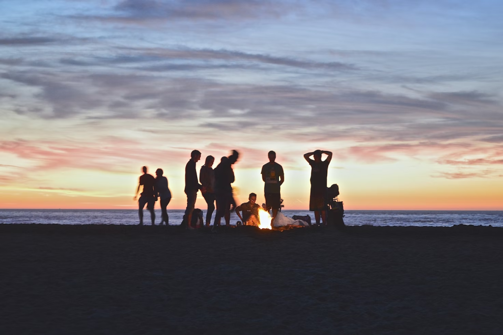 fogata en la playa con jóvenes campers