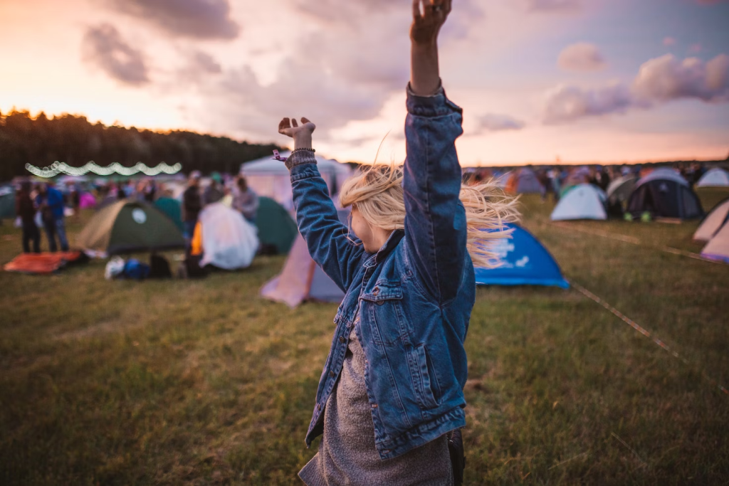 Aspectos a tener en cuenta a la hora de inscribir un adolescente en un campamento de verano | adolescente en medio de un campo con casas de campaña