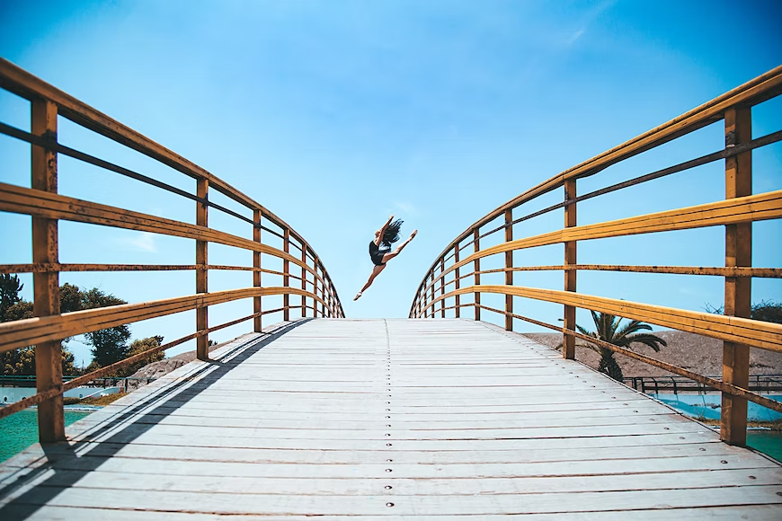 Chica saltando en un puente playero